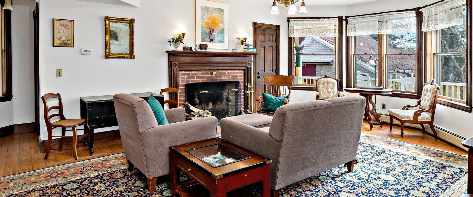 Cozy living room with a fireplace, plush seating, and large windows.